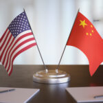 USA and Chinese flags on table. Negotiation between China and United states. 3D rendered illustration.