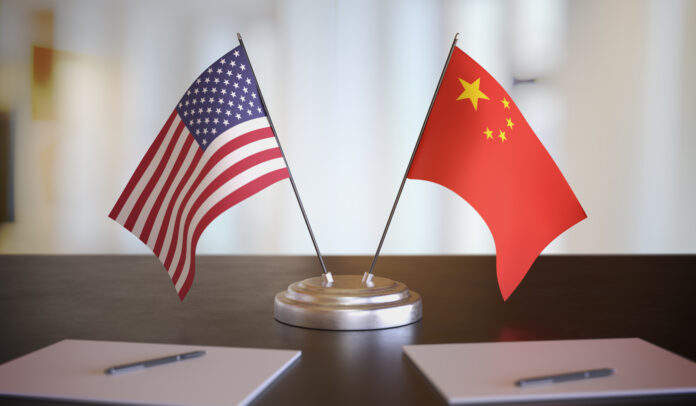 USA and Chinese flags on table. Negotiation between China and United states. 3D rendered illustration. US China Iran weapons tension Trump warning statement